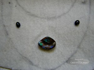 deciding what goes where the tiny black stones are star diopside, center piece is the opal